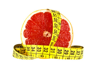 Diet concept: slice of grapefruit and measuring tape on white ba