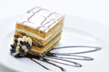 cream cake with chocolate, honey and vanilla on white plate, sweet dessert, product photography for patisserie or shop