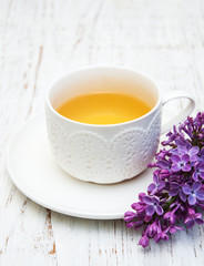 Cup of tea and lilac flowers
