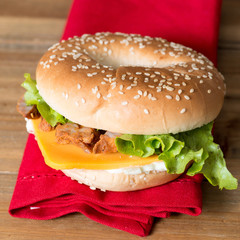 Bagel with fresh cheese and fresh lettuce on napkin
