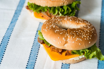 Bagel with fresh cheese and fresh lettuce on napkin