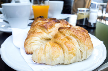 Breakfast with coffee and croissants on table