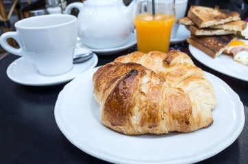Breakfast with coffee and croissants on table