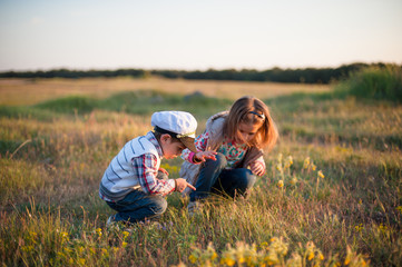 boy girl insect spring grass look point finger sun