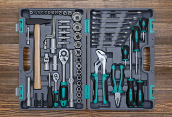 Open toolbox with different instruments on wooden workbench