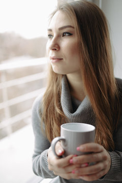 Attractive young woman sitting in a coffee shop at window