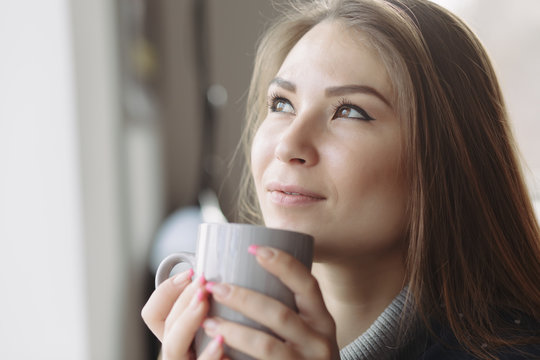 Cropped portrait of woman enjoying a drink at coffee shop