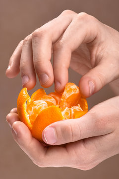 child hand peeling ripe sweet tangerine