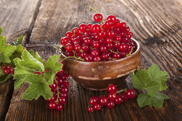 Red currant on wooden background.