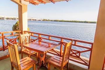 wooden chairs and table on terrace with sea views