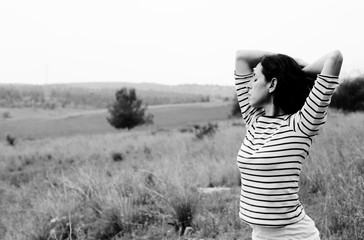 Woman with open arms standing outdoors