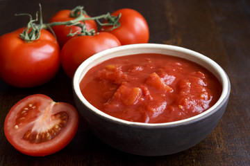 Brown ceramic bowl of chopped tinned tomatoes.