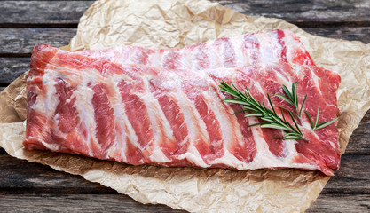 Raw Pork ribs with a rosemary. on crumpled paper