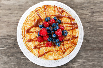 Fresh golden pancakes with raspberries, blueberries