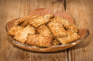 Cookies with sesame in the ceramic plate on the wooden background