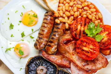 Full English breakfast with bacon, sausage, egg, beans and mushrooms