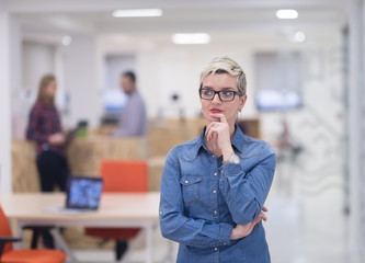 portrait of young business woman at office with team in backgrou