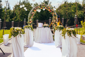 wedding ceremony arch with roses in the summer day