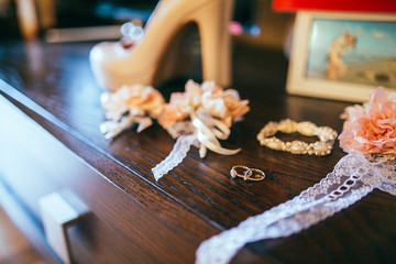 Stylish gold rings on cute white shaped pillow and other accesoris