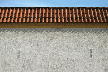 Gray fence wall.Old fence with a tiled roof as a background.