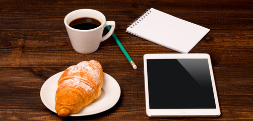 cup of coffee on table in cafe with tablet