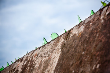 Cement wall covered with broken glass