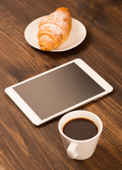 cup of coffee on table in cafe with tablet