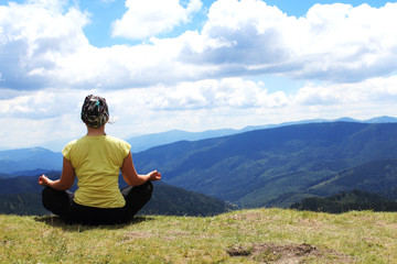 Naklejka na ściany i meble Meditating girl in mountains