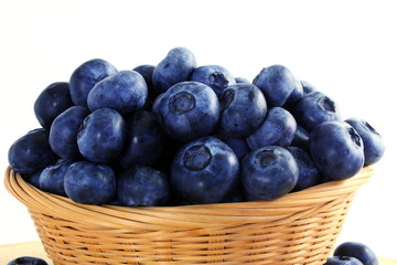 blueberries in bamboo basket on white background
