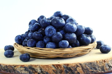 blueberries in bamboo basket on white background
