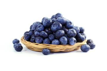 blueberries in bamboo basket on white background
