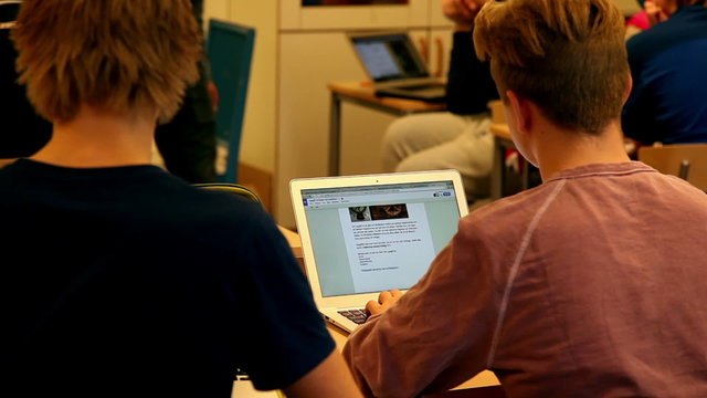 Students Inside a classroom using laptop for studying