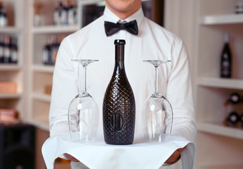 Sommelier holding tray with wine bottle