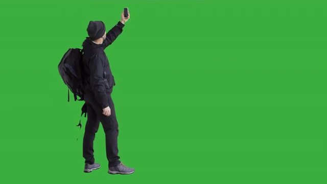 Young male hiker is trying to catch a mobile network signal - green screen. Prores 422HQ 4K UHD 60FPS slow motion shot. Shot with Blackmagic URSA Mini