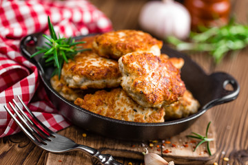 meat cutlets in frying pan on wooden rustic table