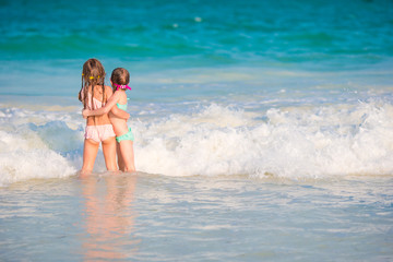 Kids having fun at tropical beach during summer vacation playing together at shallow water