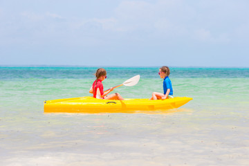 Little adorable girls enjoying kayaking on yellow kayak 