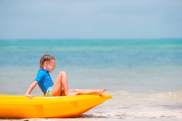 Adorable little girl kayaking during summer vacation