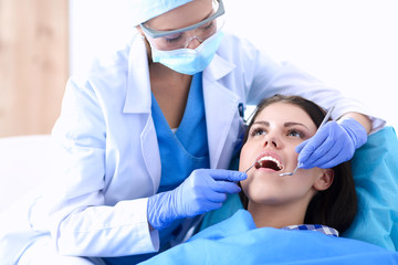 Woman dentist working at her patients teeth