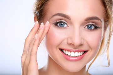 Fototapeta premium Young woman touching her face isolated on white background