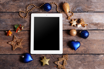 Tablet and Christmas decor on wooden background