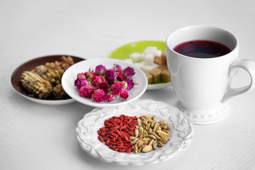 Cup of tea with aromatic dry tea on wooden background