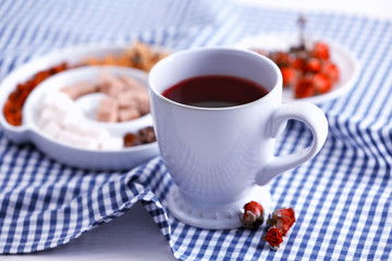 Cup of tea with aromatic dry tea on wooden background