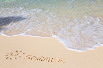 Word SUMMER on beach - vacation concept background