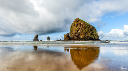 Oregon coast Haystack Rock on a dramatic cloudy day with reflections - 103952386