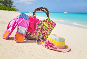 Bag, hat, flip-flops and sunglasses on sunny beach, tropical bea