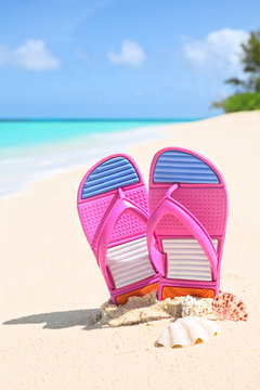 Pinks flip-flops on a sunny sandy beach..Tropical beach vacation