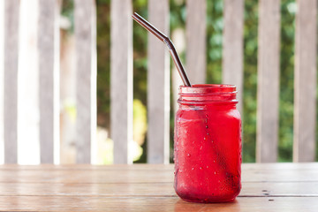 Iced drink in red glass on wooden table