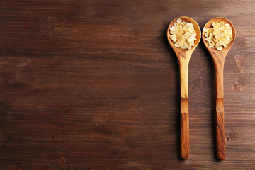 Two wooden spoons with almond flakes on the table, close-up