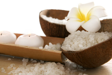 Spa concept of plumeria, coconut and candles with sea salt, isolated on white